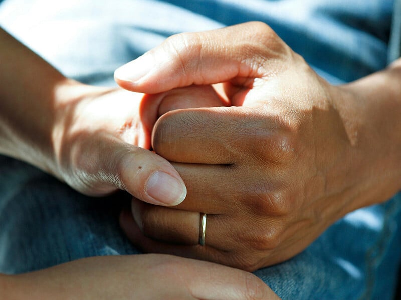 Hands embracing each other as a symbol of support in care