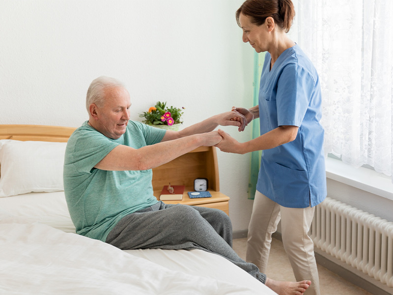 Nurse helps man out of bed