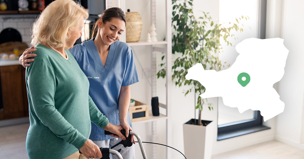 An elderly woman is helped to walk by a carer