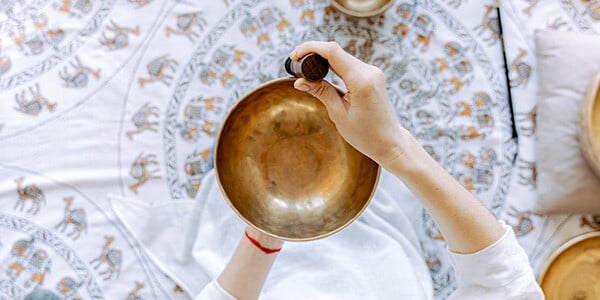 Hands of a woman holding singing bowls as a symbolic image for complementary medicine for cancer patients
