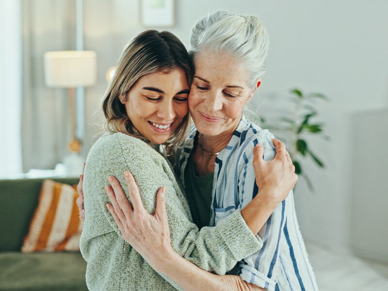 Cancer patient and caring daughter hug each other