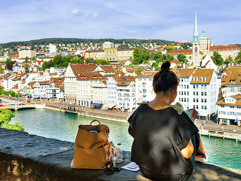 A person overlooks Zurich's old town with personal belongings on a wall, symbolizing Spitex in the canton and its proximity to the community.